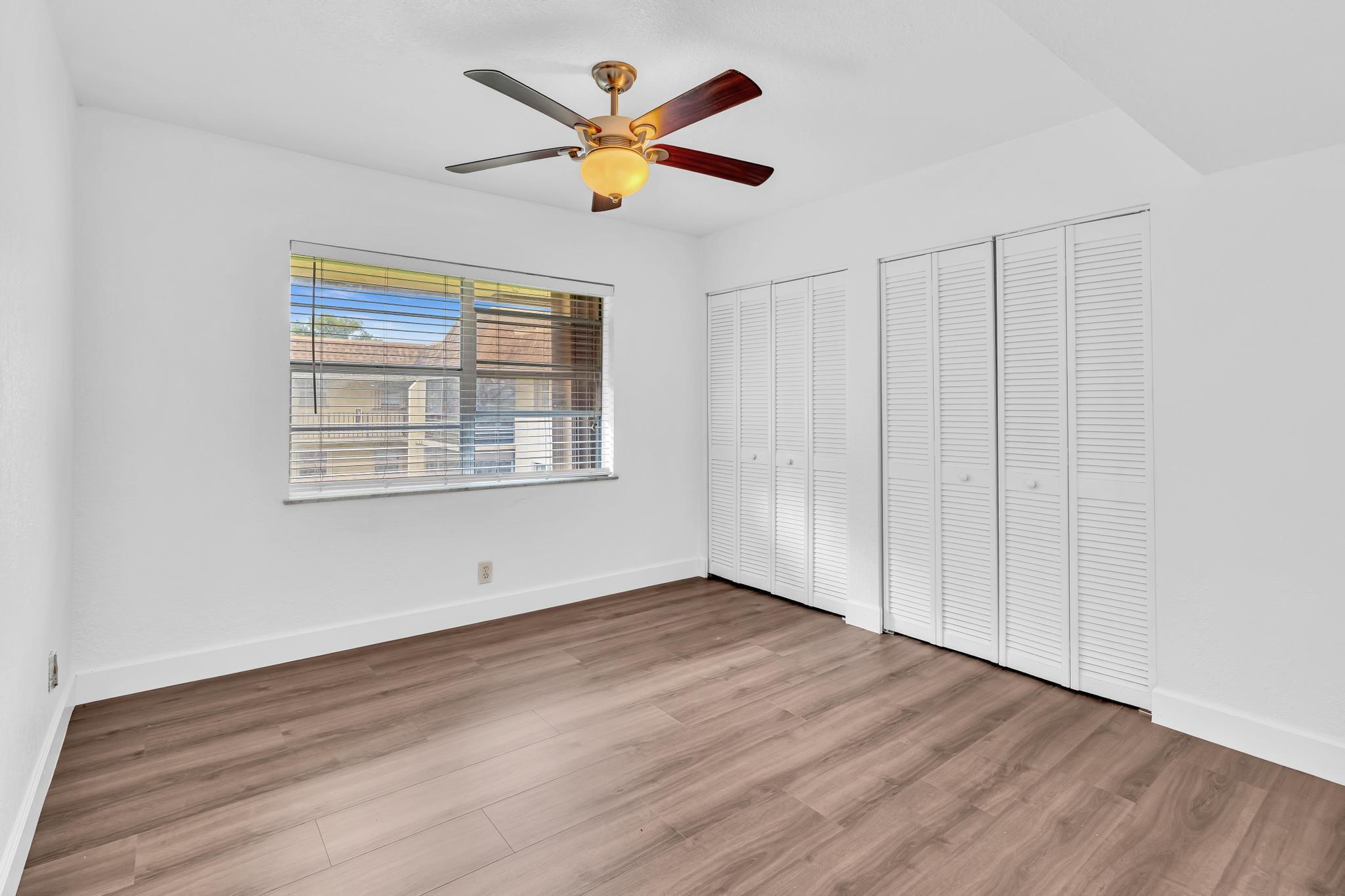 1291 Northwest 13th Street, Unit 445D Boca Raton, FL 33486 - Photo 40 of 50 an empty room with wooden floor and windows