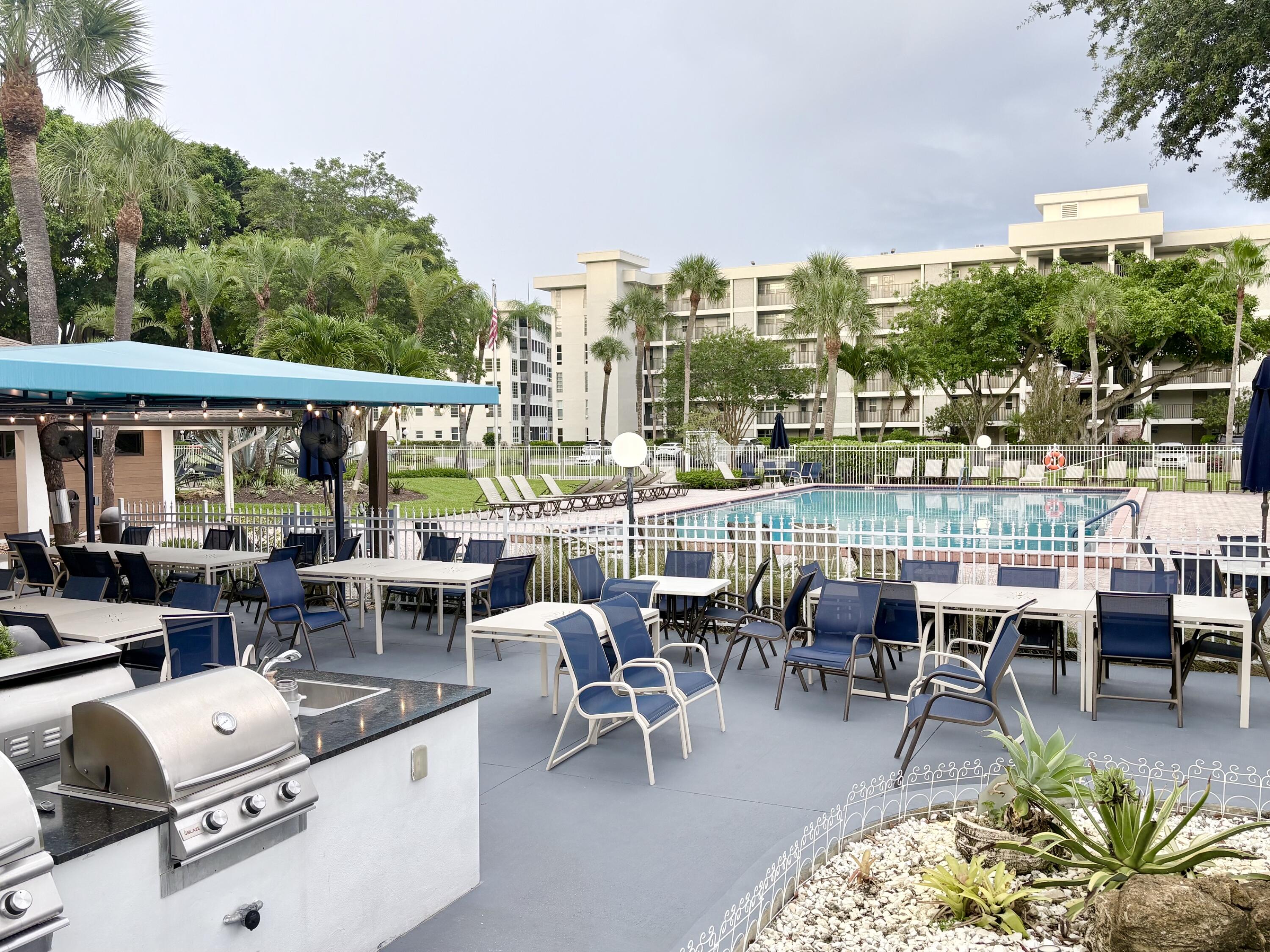2671 South Course Drive, Unit 108 Pompano Beach, FL 33069 - Photo 20 of 40 a view of a patio with dining table and chairs