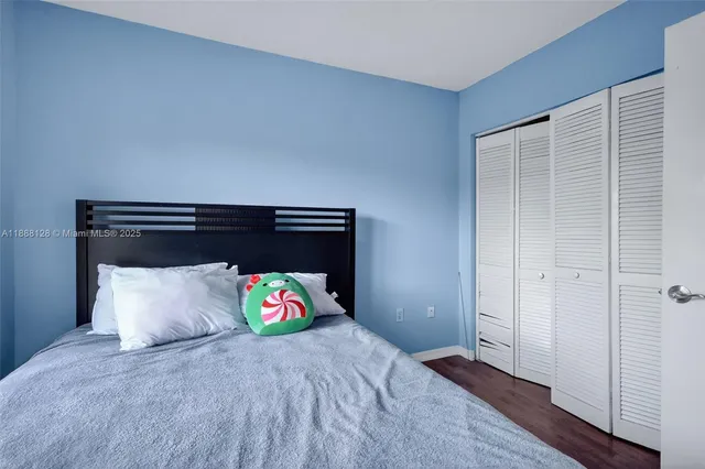 a bedroom with a bed and a wooden floor