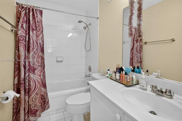 a bathroom with a sink a toilet and shower curtain