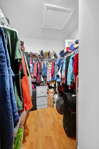 a view of walk in closet with clothes and shoes