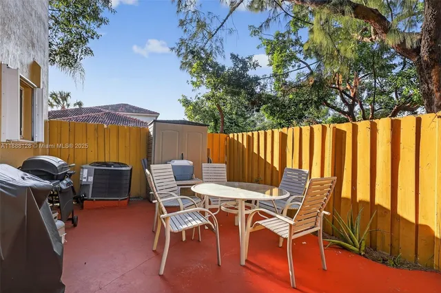 a view of a patio with table and chairs with wooden floor and fence