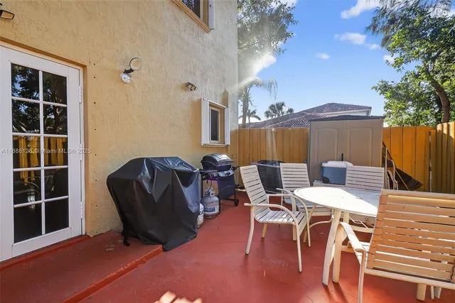 a view of a patio with table and chairs with wooden floor and fence