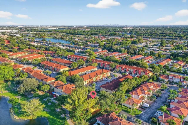 an aerial view of residential houses with outdoor space and trees