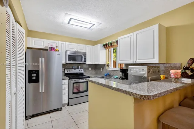 a kitchen with stainless steel appliances granite countertop a refrigerator stove and sink