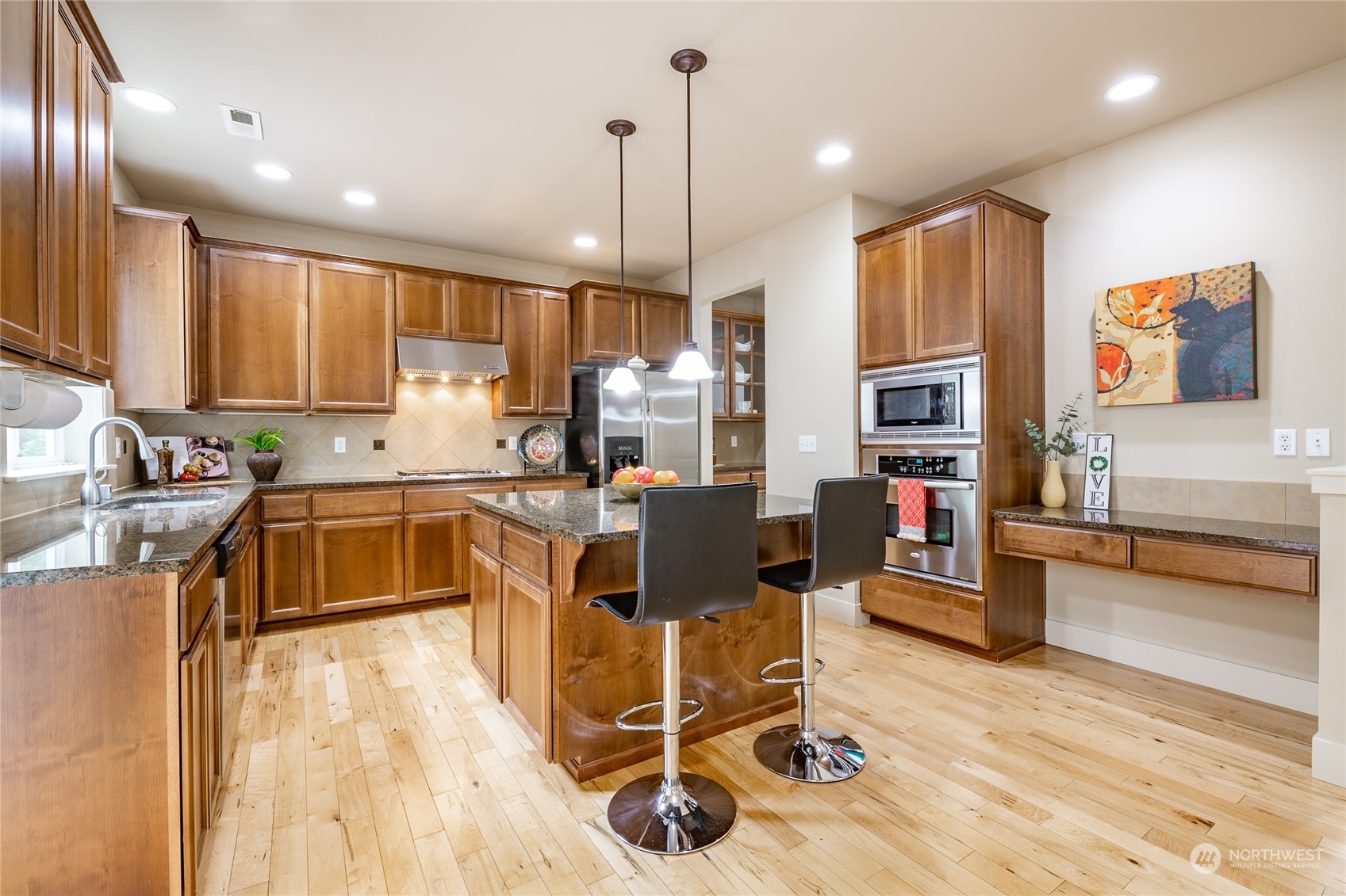 22831 36th Drive Southeast Bothell, WA 98021 - Photo 5 of 40 a kitchen with stainless steel appliances granite countertop a refrigerator a stove top oven a sink dishwasher and white cabinets with wooden floor