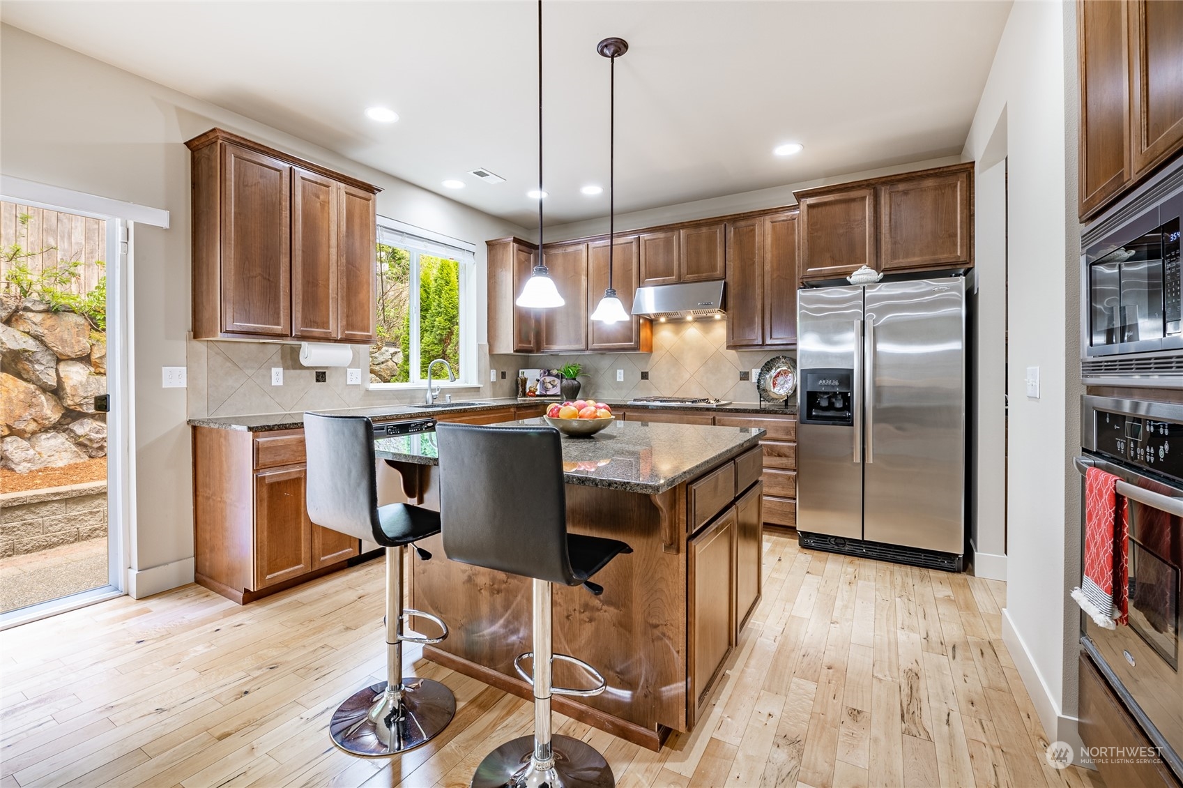 22831 36th Drive Southeast Bothell, WA 98021 - Photo 6 of 40 a kitchen with stainless steel appliances granite countertop a refrigerator a sink dishwasher a stove and a microwave oven with wooden floor