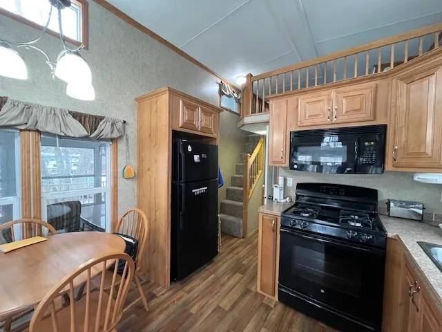 a kitchen with stainless steel appliances granite countertop a stove a refrigerator and a fireplace