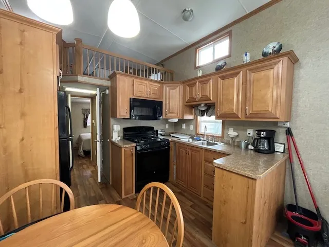 a kitchen with stainless steel appliances granite countertop a refrigerator a stove top oven a sink and dishwasher