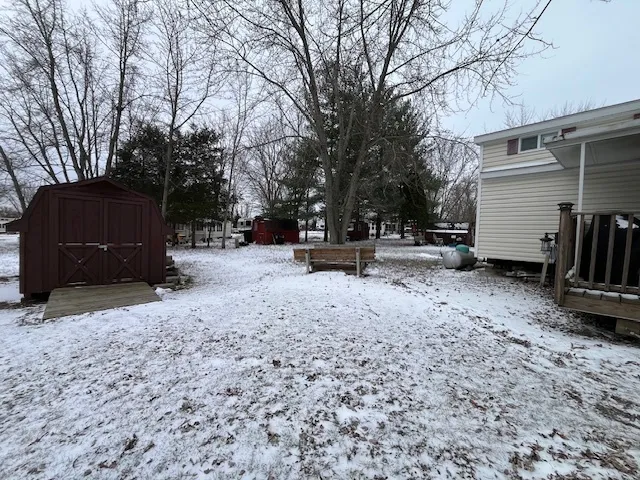 a view of a white house with a yard covered with snow