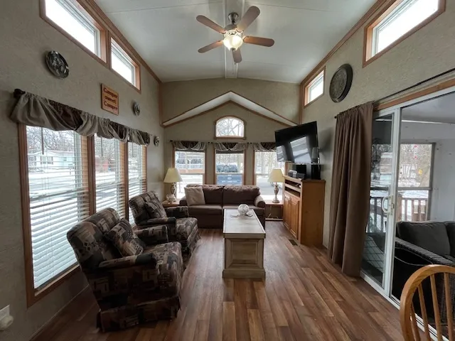 a living room with furniture a wooden floor and a large window