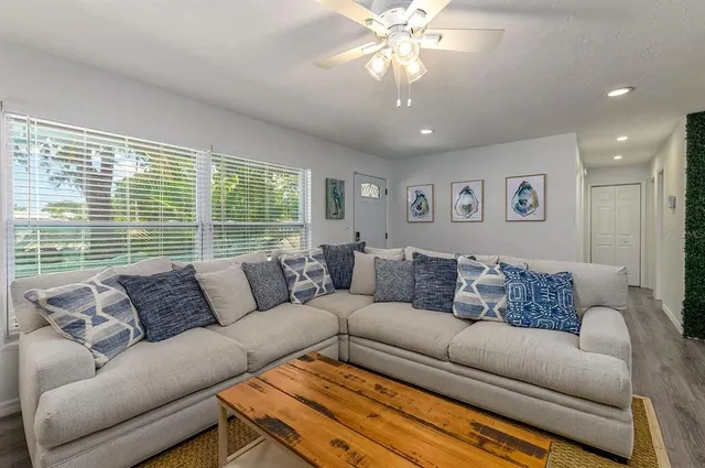 a living room with furniture ceiling fan and a rug