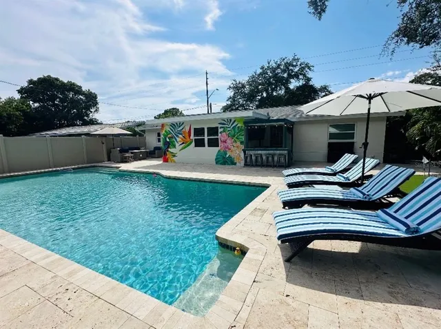 a view of a house with swimming pool and sitting area