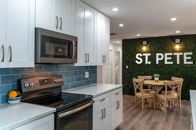 a kitchen with a sink a counter top space stainless steel appliances and cabinets