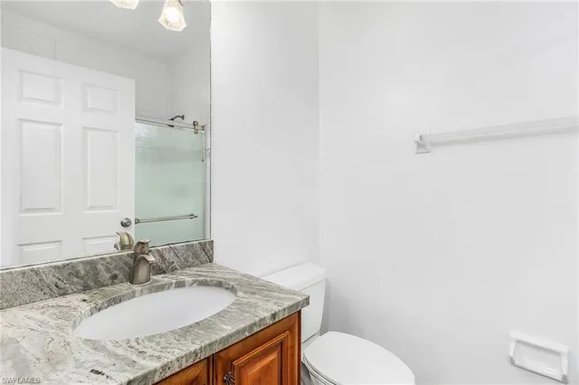 a bathroom with a granite countertop sink toilet and shower