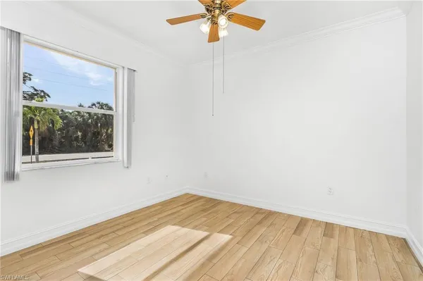 an empty room with a window and a ceiling fan