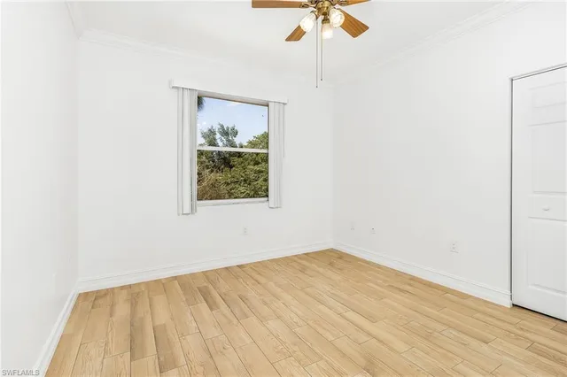 an empty room with a window and a ceiling fan