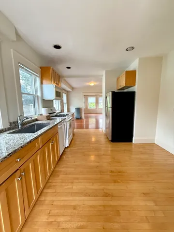 a large kitchen with stainless steel appliances granite countertop a large counter top and a stove