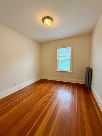 a view of a room with wooden floor and window