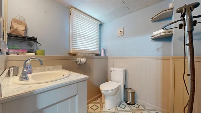 a bathroom with a sink a toilet and a mirror