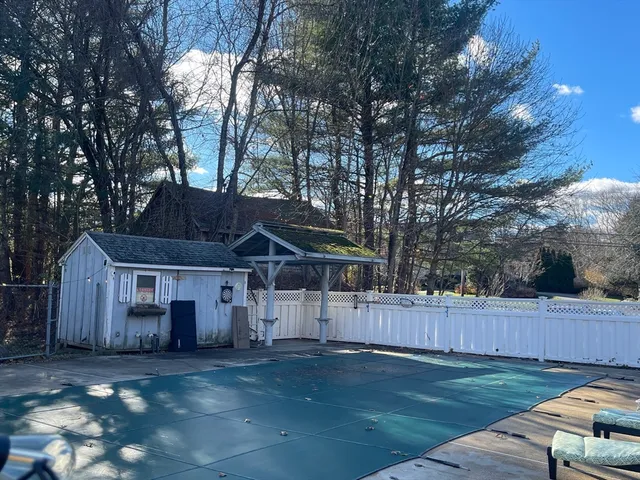 a view of a house with wooden fence and a large tree