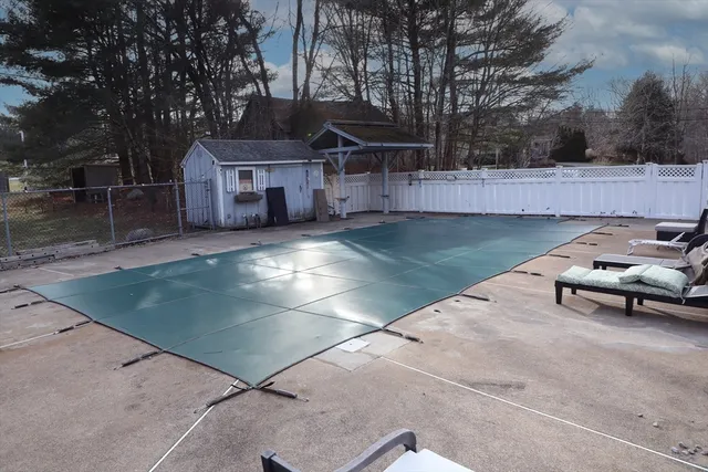 a view of a white house with a yard and sitting area
