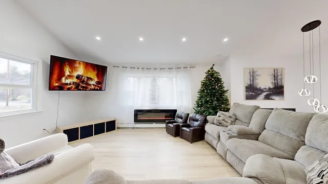 a living room with furniture a window and a flat screen tv