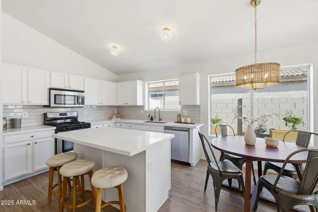 a view of a dining room and livingroom with furniture wooden floor a chandelier