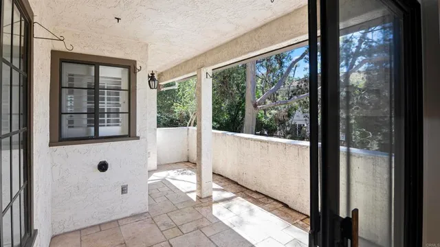 an empty room with wooden floor door and windows