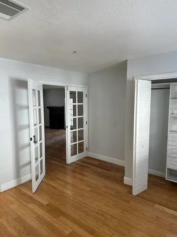 a view of an empty room with a window and wooden floor
