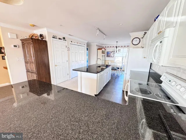 a kitchen with stainless steel appliances granite countertop a sink refrigerator and cabinets