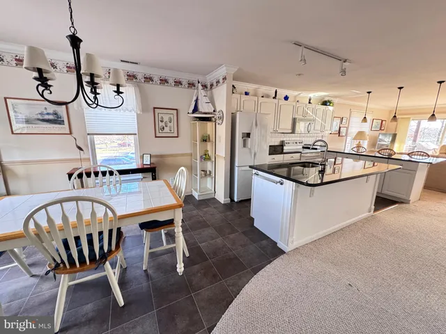 a large white kitchen with a granite countertop sink