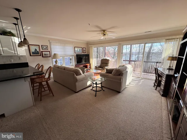 a living room with furniture kitchen view and a chandelier