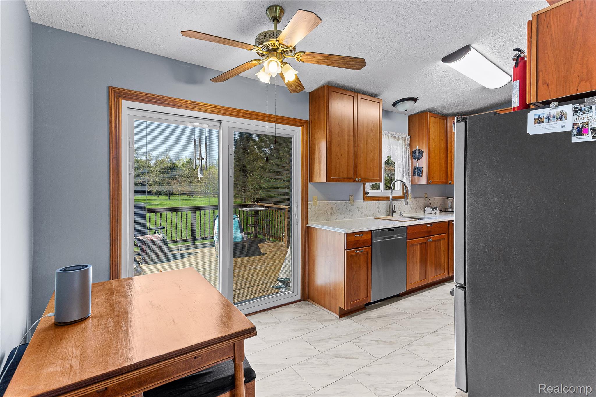 961 Jolly Road Okemos, MI 48864 - Photo 7 of 29 Kitchen featuring stainless steel appliances, wood finish cabinetry, light countertops, a ceiling fan, and a textured ceiling