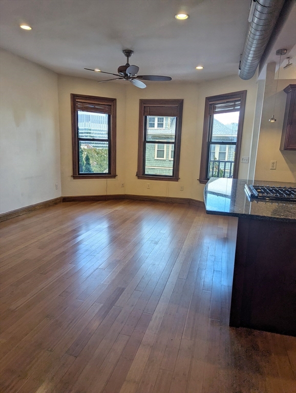 176 Hillside Street, Unit 101 Boston, MA 02120 - Photo 4 of 16 an empty room with wooden floor and windows