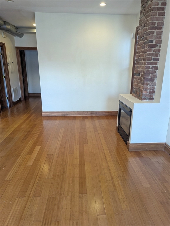 176 Hillside Street, Unit 101 Boston, MA 02120 - Photo 5 of 16 a view of an empty room with wooden floor and a window