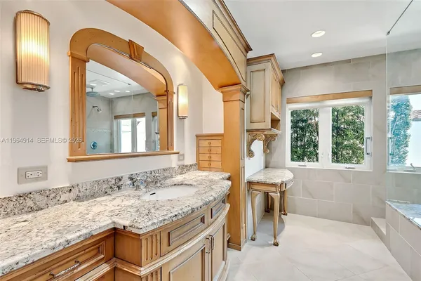 a bathroom with a granite countertop sink and a bathtub