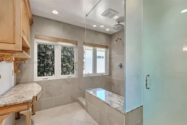 a bathroom with a granite countertop sink a mirror and a bathtub