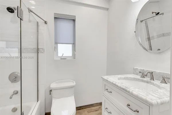 a bathroom with a granite countertop sink a toilet and a mirror