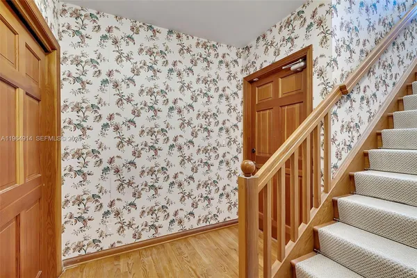 a view of a hallway with wooden floor and stairs