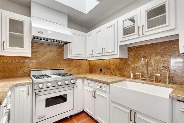a view of a kitchen with sink and washer dryer