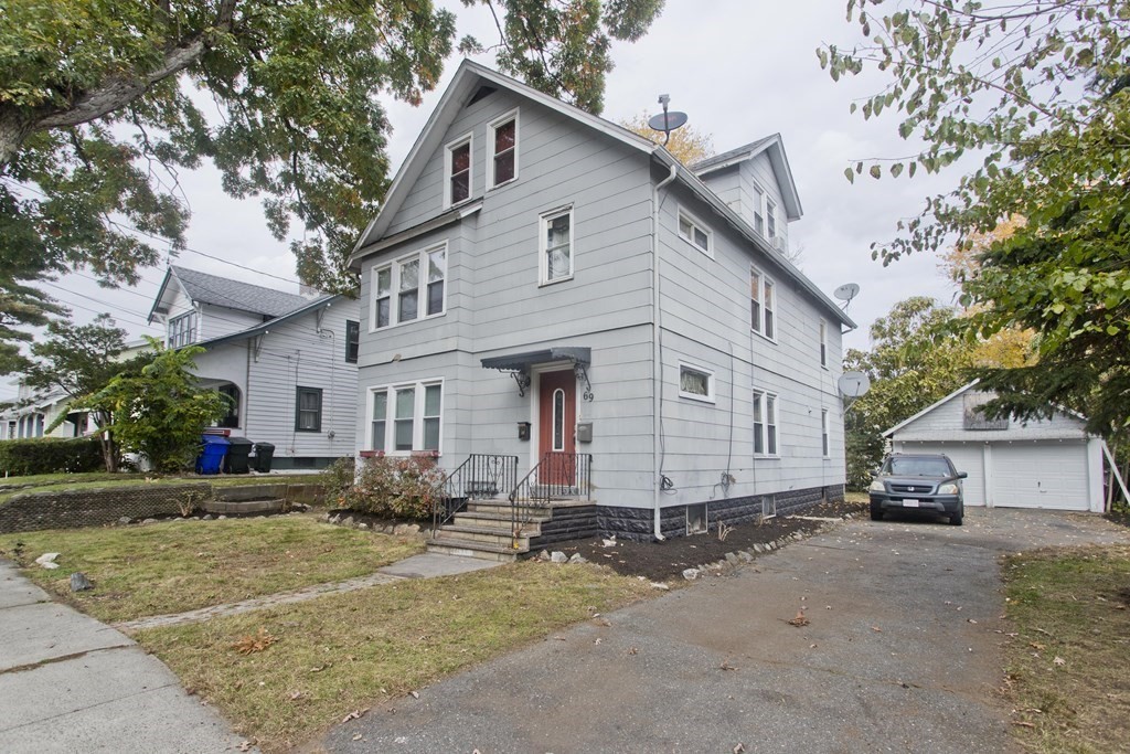 69 Appleton Street Springfield, MA 01108 - Photo 2 of 34 a view of a white house with a large windows and a small yard