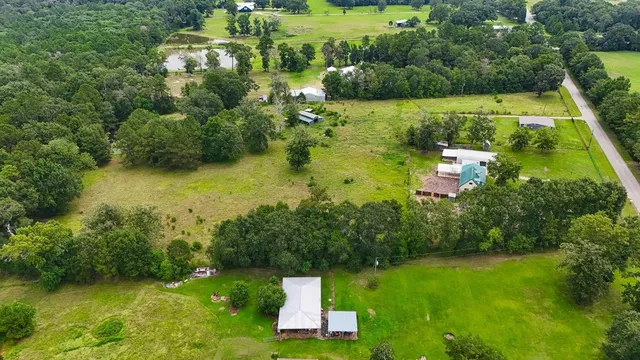 an aerial view of residential houses with outdoor space and trees