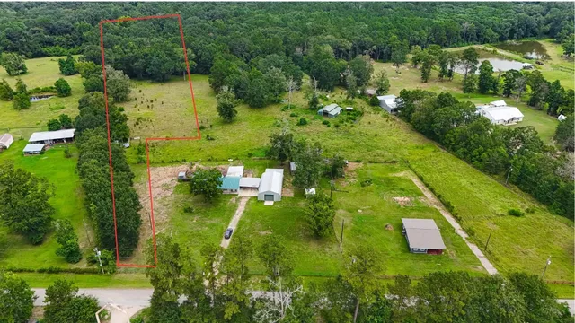 an aerial view of residential houses with outdoor space and trees