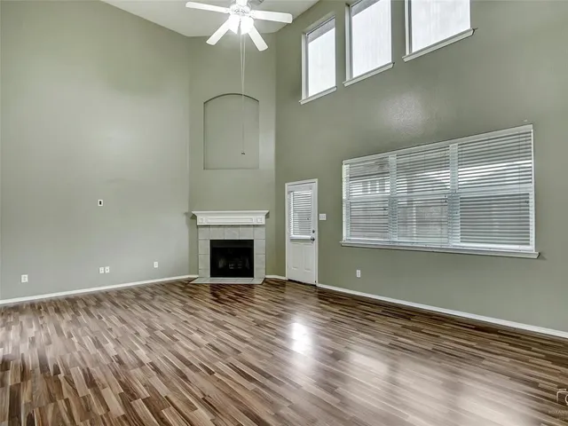 a view of empty room with wooden floor and fireplace