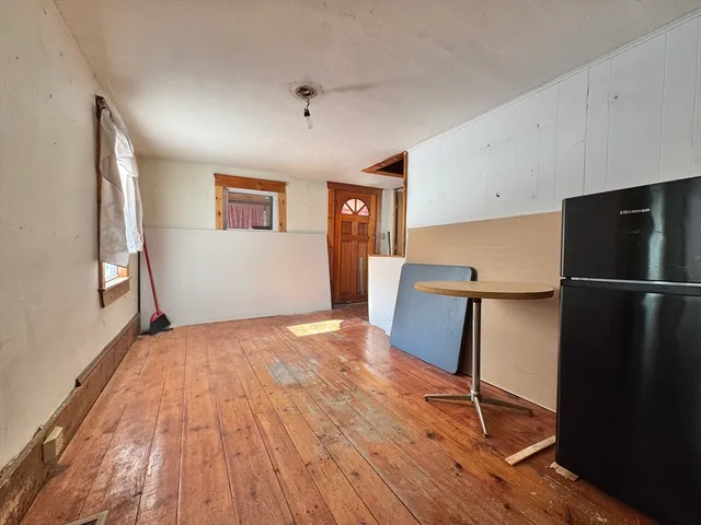 a view of a kitchen with wooden floor and a refrigerator