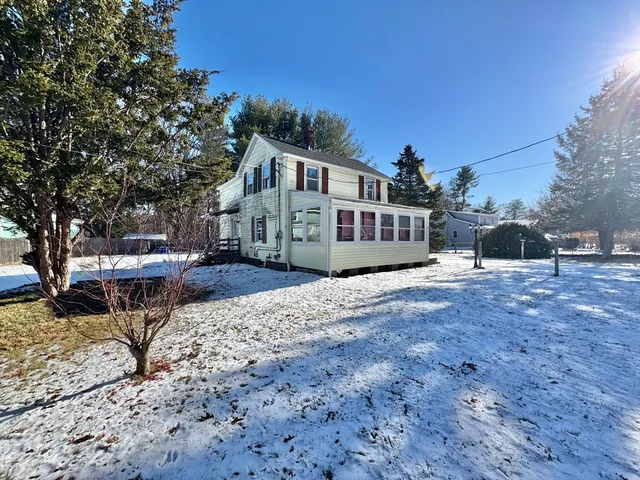 a view of a house with a yard covered in snow