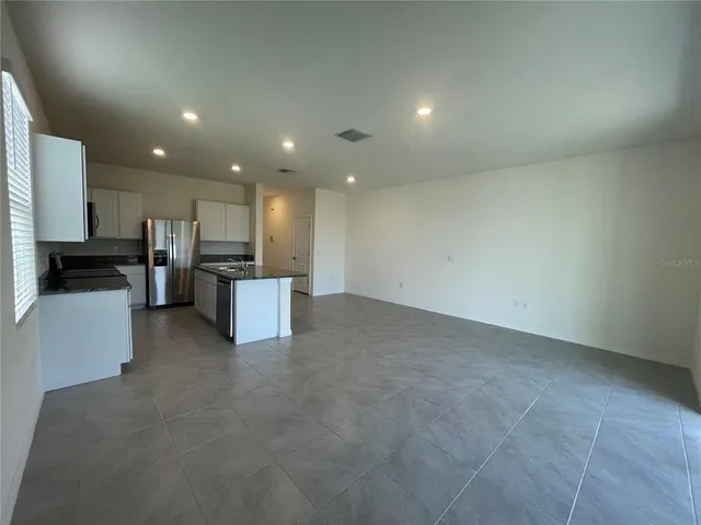 a view of kitchen with stainless steel appliances refrigerator sink and microwave