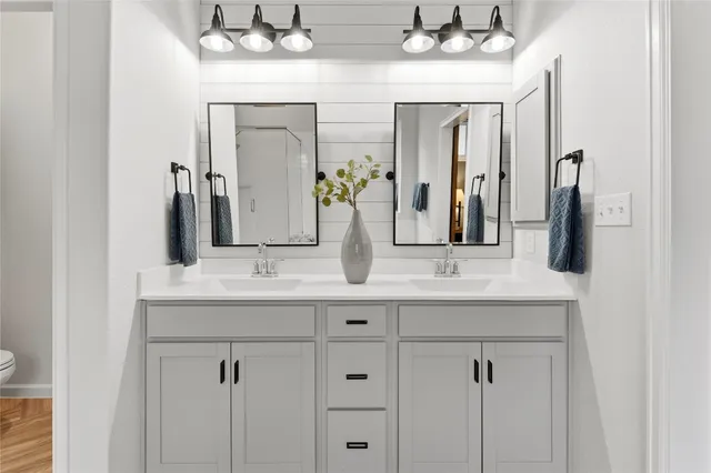a bathroom with double vanity sinks and a mirror