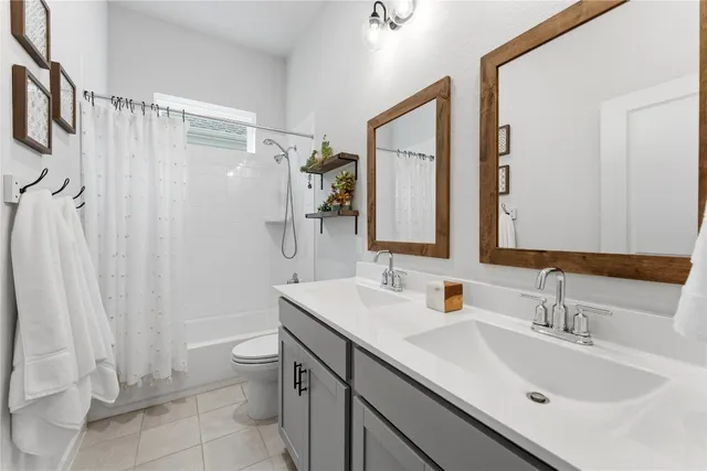 a bathroom with a double vanity sink mirror and toilet